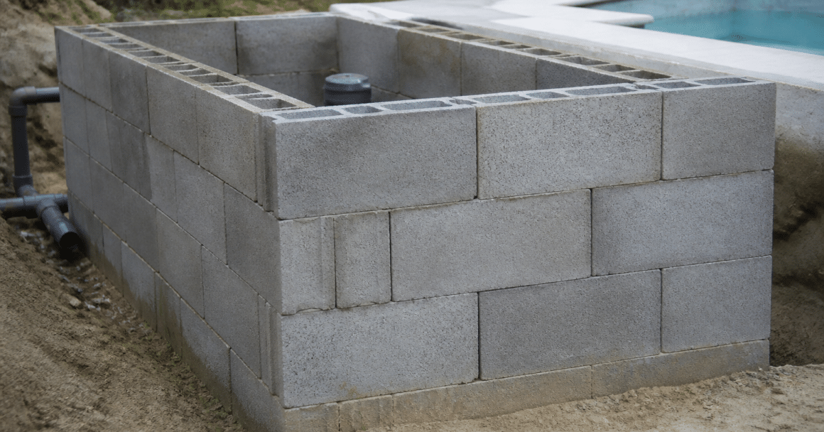Mur de parpaings empiles horizontalement formant structure technique piscine