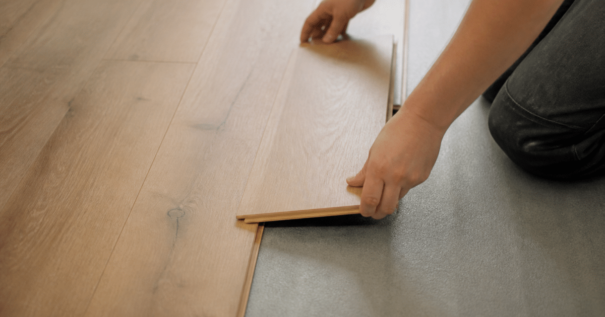 Mains posant planches bois sur sous-couche isolante grise