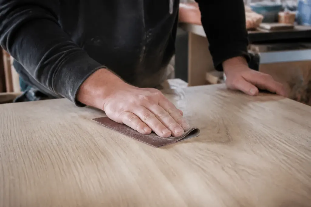 Main ponçant surface bois avec grain abrasif progressif
