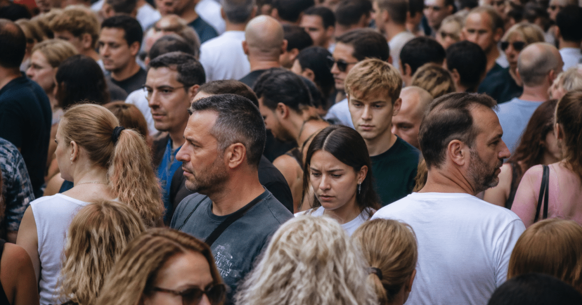 Foule dense de personnes debout côte à côte dans rue urbaine
