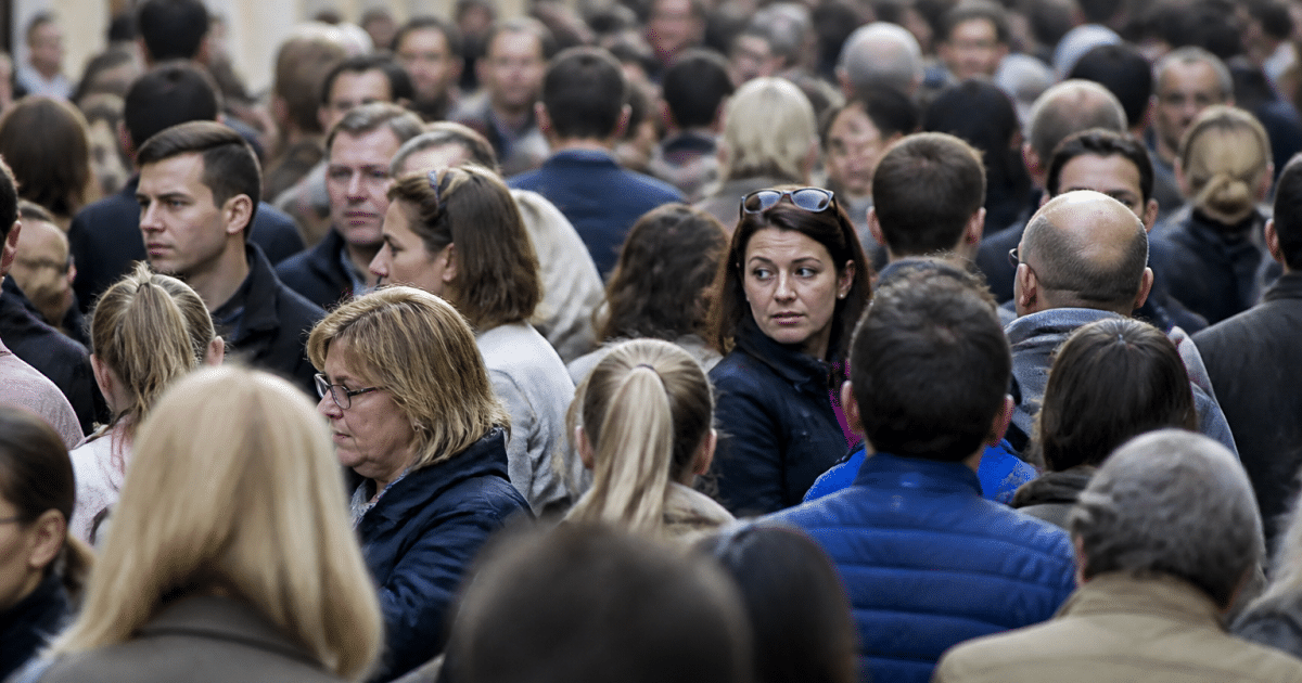 Foule dense de personnes debout cote a cote dans rue urbaine