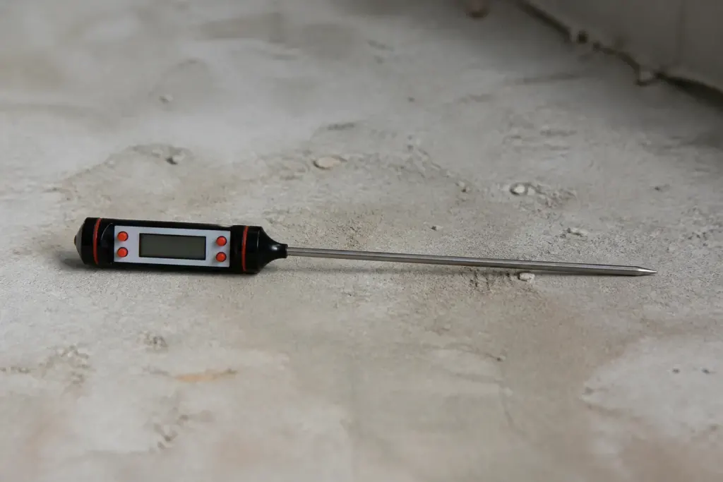 Thermometre digital pose sur une chape beton brute